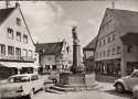 Ansichtskarte: Burgau - Marienbrunnen - Th. Becker - A. Frey Textilhaus Chem. Reinigung Textilreinigung - Michael Zink Spielwaren Korb- Lederwaren - Oldtimer - Landkreis G�nzburg - Schwaben - Bayern  ...